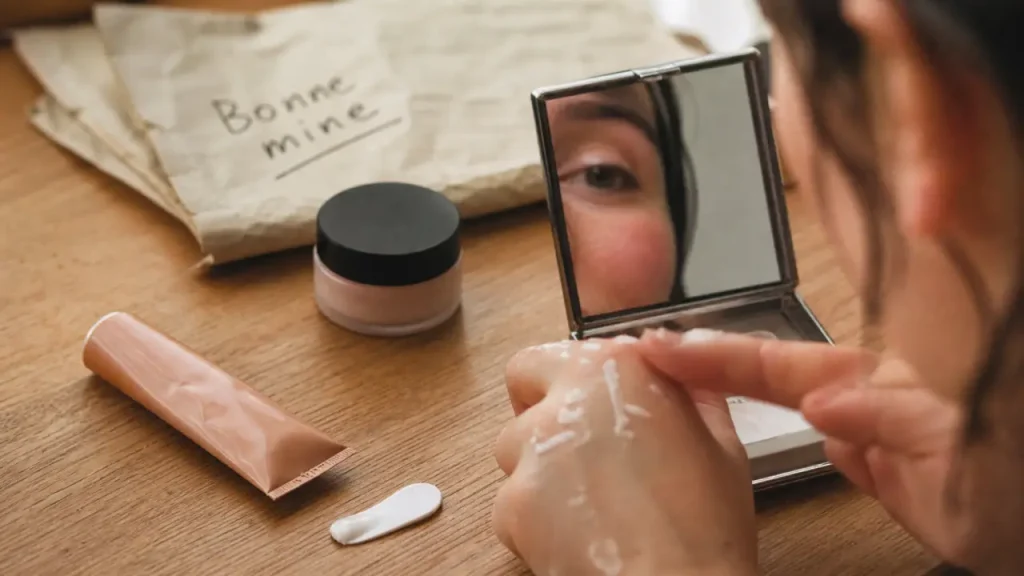 Creme bonne mine : tube et pot de crème, main et miroir